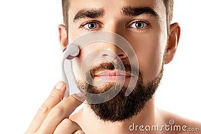 Handsome man using meso roller for better beard growth Stock Photo