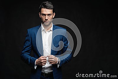 Handsome man wear blue suit isolated on black background. Stock Photo