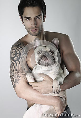 Handsome man wearing a cute french bulldog Stock Photo