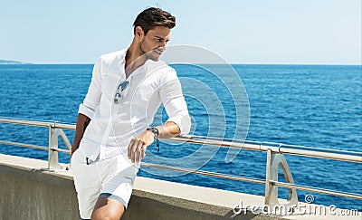 Handsome man wearing white clothes posing in sea scenery Stock Photo