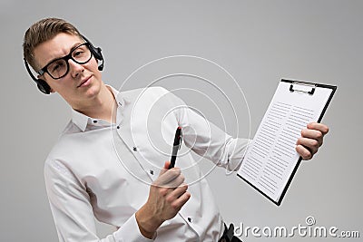 Young man in glasses and headphones with insurance in hands isolated on white background Stock Photo