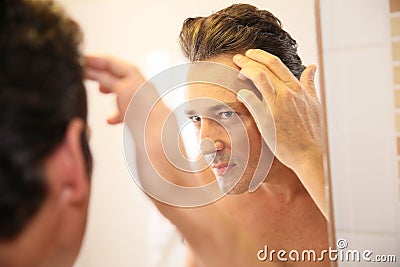 Handsome man worrying about his hair loss Stock Photo