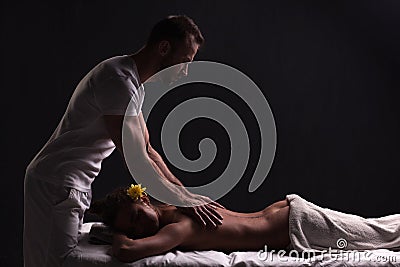 Handsome masseur doing massage for brunette woman Stock Photo