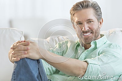 Handsome Mature Man Relaxing On Sofa Stock Photo