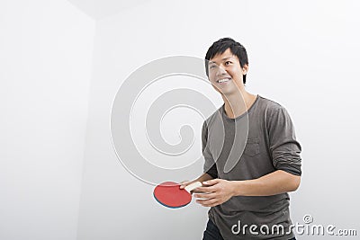 Handsome mid adult man holding table tennis paddle Stock Photo