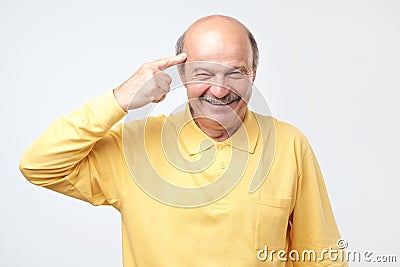 Senior man smiling pointing to head with one finger, great idea or thought Stock Photo