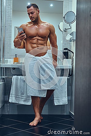 A handsome muscular male in stylish twin bathroom. Stock Photo