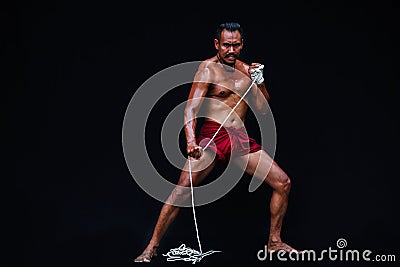 Handsome Muscular Man displays ancient Asian traditional martial arts, Thai Boxing or Muay Thai Stock Photo
