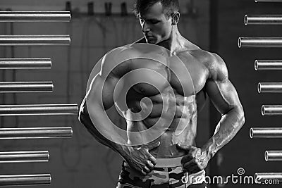 Handsome muscular man showing muscles, posing in gym. Strong male torso abs, workout Stock Photo