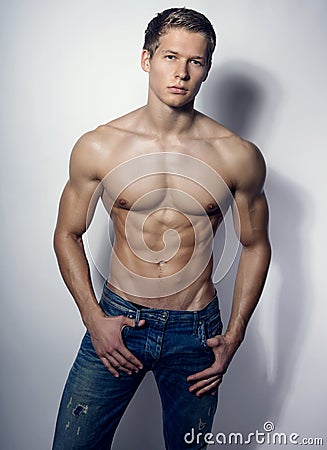 Handsome muscular young bodybuilder showing his muscles and abs Stock Photo