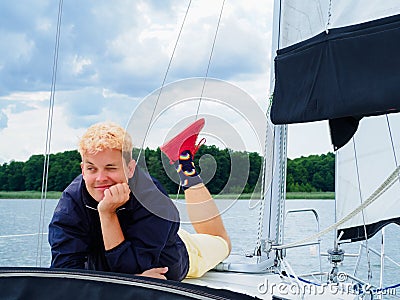 Handsome person laying on yacht deck and enjoying on a sailing yacht on vacations Stock Photo