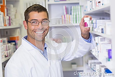 Handsome pharmacist holding medicine jar Stock Photo