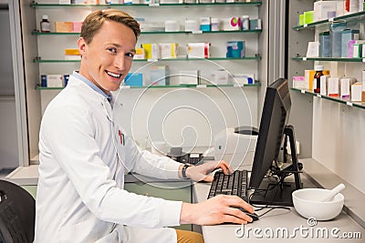 Handsome pharmacist using the computer Stock Photo