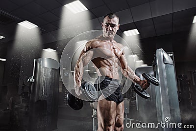 Handsome power athletic bodybuilder in training pumping up muscles Stock Photo