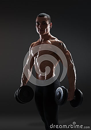 Handsome power athletic man bodybuilder doing exercises with dum Stock Photo