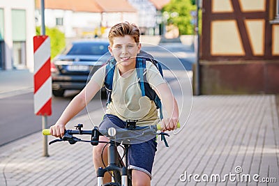Handsome preteen boy going to school on bike. Teenager ride bicycle. Safe way to high school. Happy child boy with Stock Photo