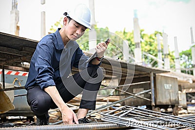 Handsome Asian male civil engineer checking the steel rod at the construction site Stock Photo