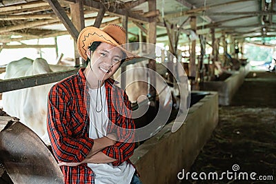 handsome rancher wearing a cowboy hat with crossed hands pose Stock Photo