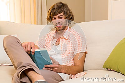 Handsome reading a book sitting on the couch Stock Photo