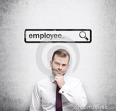 A handsome recruiter by holding his chin is looking for new employees in the Internet. Internet concept of search available candid Stock Photo