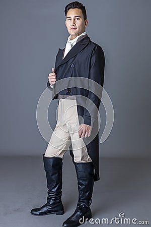 A Regency gentleman wearing a tailed jacket against a grey backdrop Stock Photo