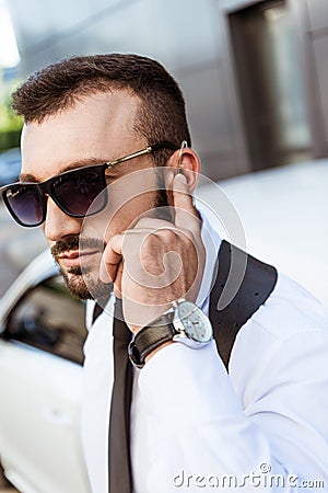 Handsome security guard listening message with security earpiece on street Stock Photo