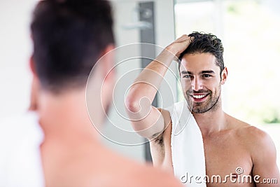 Handsome shirtless man looking in the mirror Stock Photo