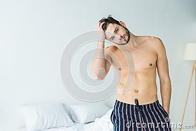 handsome shirtless man posing in bedroom Stock Photo
