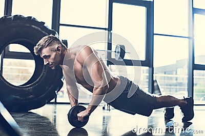 handsome shirtless sportsman exercising with abs roller Stock Photo