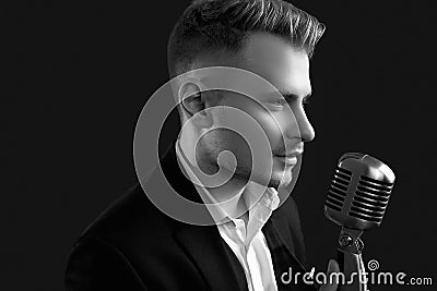 Handsome singer in elegant tuxedo and bow tie with vintage microphone Editorial Stock Photo