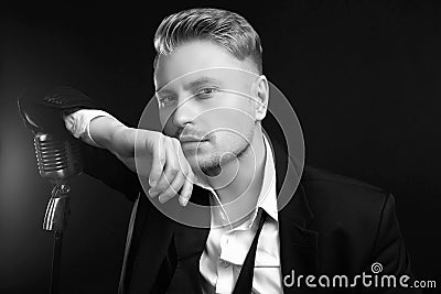 Handsome singer in elegant tuxedo and bow tie with vintage microphone Editorial Stock Photo