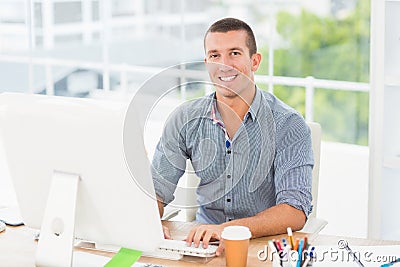 Handsome smiling businessman typing on a computer Stock Photo