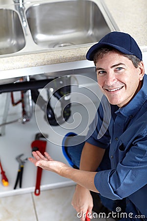 Smiling plumber repairs a sink. Stock Photo