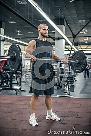 Handsome strong bald athletic fitness men pumping up arm muscles workout barbell curl fitness concept background - muscular Stock Photo
