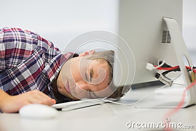 Handsome student dozing in the computer room Stock Photo