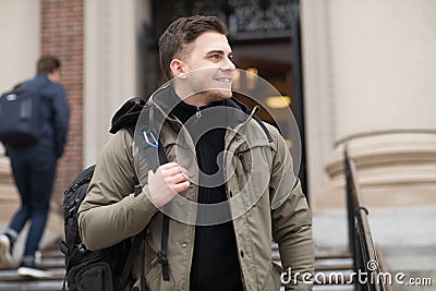 Handsome student walking in college campus with a backpack to the class. Stock Photo