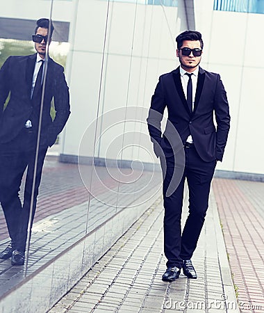 Handsome stylish man in elegant black suit and sunglasses Stock Photo