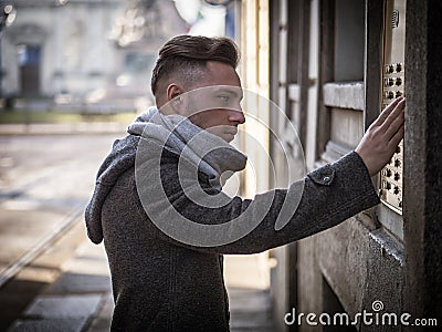 Handsome stylish young man ringing doorbell at building Stock Photo