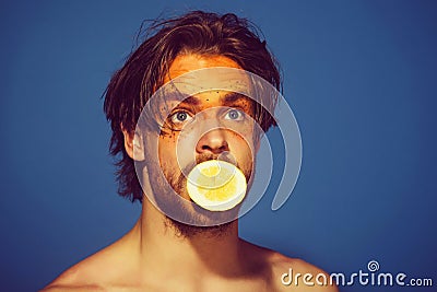 Handsome surprised man with creative fashionable makeup hold lemon, vitamin Stock Photo