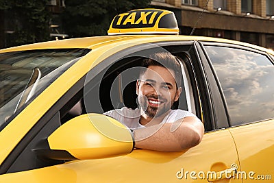 Handsome taxi driver in car on city street Stock Photo