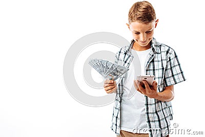 Handsome Teen guy with money in his hands, writes on the phone, joyful man holding dollars, in Studio on white background Stock Photo