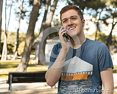 Handsome teenager talking on a mobile phone outdoors Stock Photo