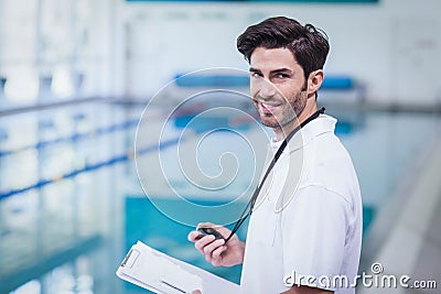 Handsome trainer holding stopwatch and reading clipboard Stock Photo