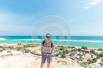 Handsome traveler man stay by blue ocean background - Happy guy relaxing at sea view point - Concept of freedom and Stock Photo