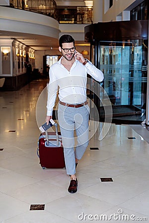 handsome traveler walking in hotel and talking Stock Photo