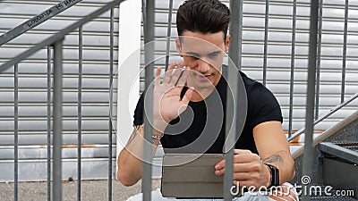 Handsome trendy man looking down at a tablet computer, outdoor Stock Photo