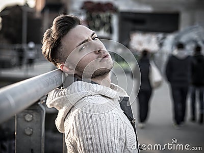 Handsome trendy young man, standing on a sidewalk in city Stock Photo