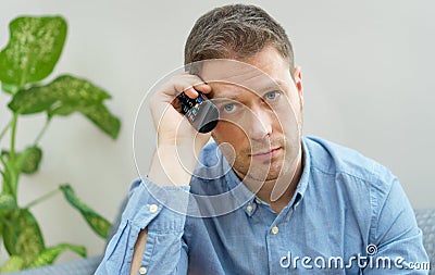 Man watching boring TV show. Stock Photo