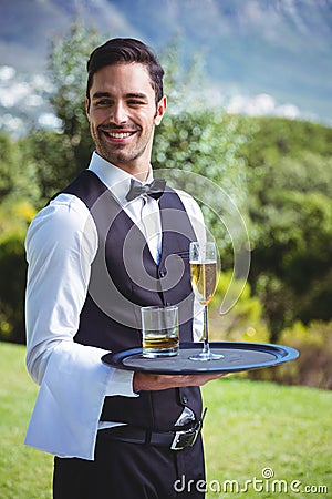 Handsome waiter holding a tray with drinks Stock Photo