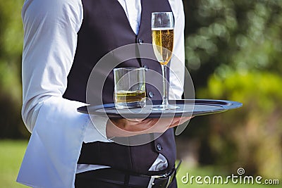 Handsome waiter holding a tray with drinks Stock Photo